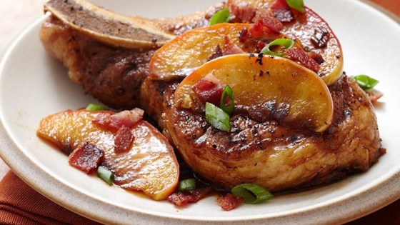 Pan seared pork chops topped with brown sugar glazed apples and bacon